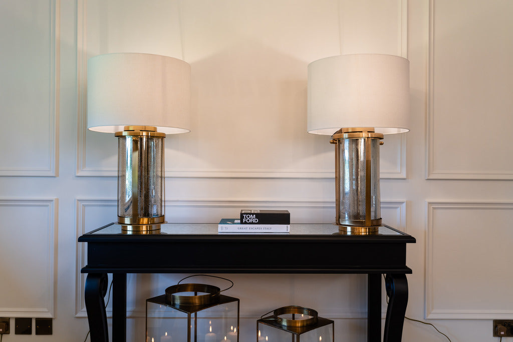 black furniture, black console table, indoor furniture, large white lampshade, lighting, gold lamps
